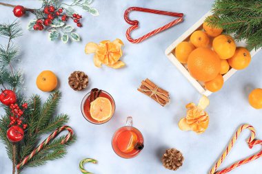 Noel sıcak şarap ya da şenlik masasında limon ve tarçınlı içki. Köknar dalları, mandallar, tatlılar, yeni yılın arka planı, diyet ve kilo kaybı konsepti, metin için boşluk,