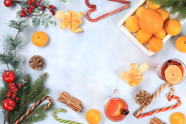 Noel sıcak şarap ya da şenlik masasında limon ve tarçınlı içki. Köknar dalları, mandallar, tatlılar, yeni yılın arka planı, diyet ve kilo kaybı konsepti, metin için boşluk,