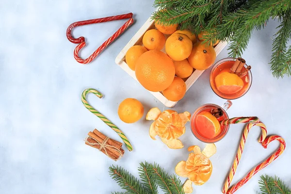 Christmas hot mulled wine or grog with lemon and cinnamon on the festive table. Winter composition with fir branches, tangerines, sweets, new year\'s background, diet and weight loss concept, space for text,