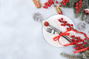 Yeni yıl sofrasında tabaklar, köknar dalları, süslemeler ve koniler, şenlikli atmosfer, akşam yemeği hazırlıkları,