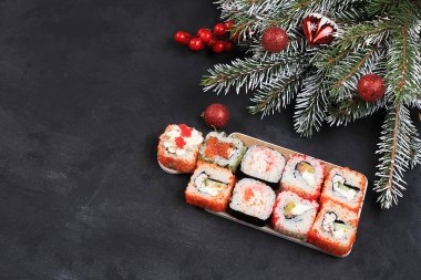 Herringbone taze suşi rulolarından yapılmış, soslu, yeni yıl yemeği, geleneksel Japon mutfağı, yazı için yer, üst manzara, mağaza reklamı veya davetiye için pankart, seçici odaklanma.