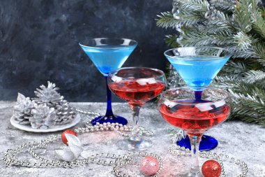 Limonata, şampanya ya da martinili pembe ve mavi alkollü kokteyl. Noel şenlikli bir masada, köknar dalları, süslemeler, bar konsepti, partideki ruhlar, seçici bir odaklanma.