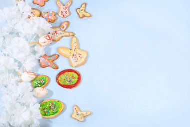 Mutlu Paskalya konsepti, bahar kartı, çiçekli kompozisyon, kurabiyeler ve yumuşak bir arka planda yumurtalar. Tatil minimal konsepti, ev yapımı fikirler, metin için yer, ekran için pankart, seçici odaklanma