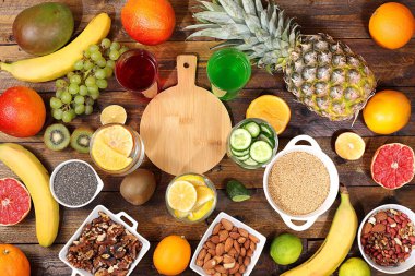 Detoks diyeti ve kilo verme konsepti. Meyve suyu ve malzemeler, yaz tropikal meyveleri, fındık, chia tohumları ve mercimek ahşap bir masa, üst görünüm, sağlıklı ve doğal yiyecek, C vitamini kaynağı, seçici odaklanma,