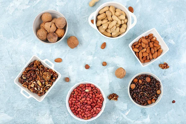 Assortment of different nuts, healthy natural food concept, almonds, pecans, pistachios, cashews, walnuts and pine nuts, high-calorie food with vegetable protein and vitamins,