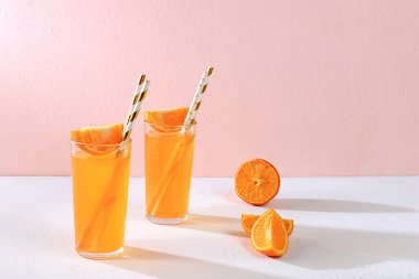 Renkli pembe arka planda turunçgil meyveleri, portakal suyu ve içerikli modern hayat. Uzun, sert gölgeler, minimum detoks diyeti konsepti, yaz vitamini içecekleri, seçici odaklanma, metin için yer.