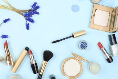 Hafif arka planda kozmetik ürünleri ve bahar muscari çiçekleri, toz, ruj, gölgeli düz laei karışımı. Yaratıcı kadınsı yaz güzellik konsepti, metin yeri olan kozmetik salonu reklamı, seçici odak