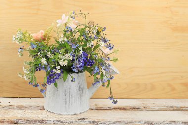 Dekor elementleriyle iç mekan, hafif arka planda vazoda güzel bahar bahçesi çiçekleri, soyut çiçek aranjmanı, metin için yeri olan hayat, doğum günü için çiçek kartı, düğün, seçici odak