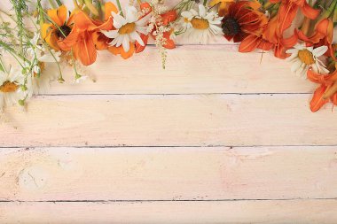 Metin, natürmort, sonbahar afişi, zambaklar ve ahşap arka planda papatya çiçekleri barındıran soyut bir kompozisyon. Anneler günü kartı, kadınlar günü, sevgililer günü, mutlu yıllar, düğün, seçici odaklanma.