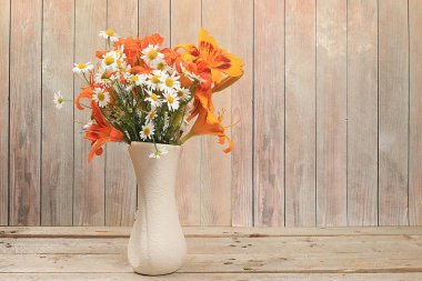 Soyut çiçek aranjmanı, arka plan, çiçekli asgari tatil konsepti, sonbahar-yaz afişi. Zambak ve papatya çiçekleri bir vazonun içinde ahşap bir arka planda, kırsal tarzda, mesaj için yeri olan kartpostallar. Seçici odak