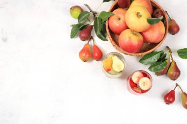 Elma ve armut armudu armut şarabı, bal, elma suyu, meyve suyu ya da meyve suyu. Güneşli bir masada, taze armut ve elmalarla dolu bir sepetin içinde. Diyet ve kilo kaybı kavramı, köyde hasat. Sağlıklı beslenme, vücut detoksifikasyonu, seçici odaklanma