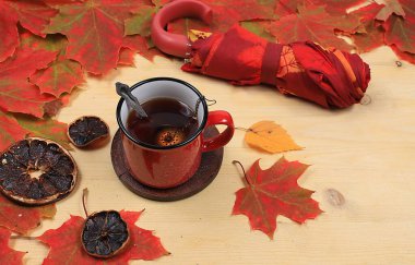 Tarçın ve mevsimlik yapraklı bir fincan sıcak çay, sonbahar çiçek aranjmanı, yazı için yeri olan soyut düz arka plan, asgari tatil konsepti, şükran günü. rustik biçim, seçici odak