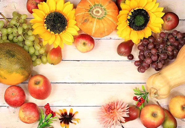 Thanksgiving background, harvest concept, autumn composition with fruits, nature berries, watermelons, melons, wheat, apples, flowers and ears of wheat and rye on a wooden background, rustic style, selective focus