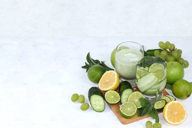 Hafif bir arka planda sebzeler, meyveler, meyve suları ve kokteyller. Kilo kaybı, yaşam tarzı, detoks diyeti için sağlıklı ve doğal besin kavramı, amacı karbonhidratları ortadan kaldırmak ve vücudu zehirden arındırmak.