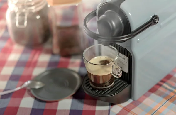 Máquina que serve café expresso em uma xícara de vidro — Fotografia de Stock