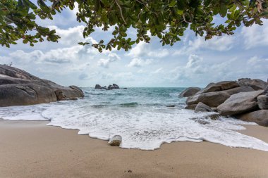 Güneşli gökyüzü olan tropik plajdan deniz manzarası. Koh Samui adasının yaz cenneti plajı. Tropikal sahil. Tayland 'da tropik deniz. Ufukta bulutlar olan egzotik yaz plajı. Okyanus kumsalı, rahatla, dışarı çık.