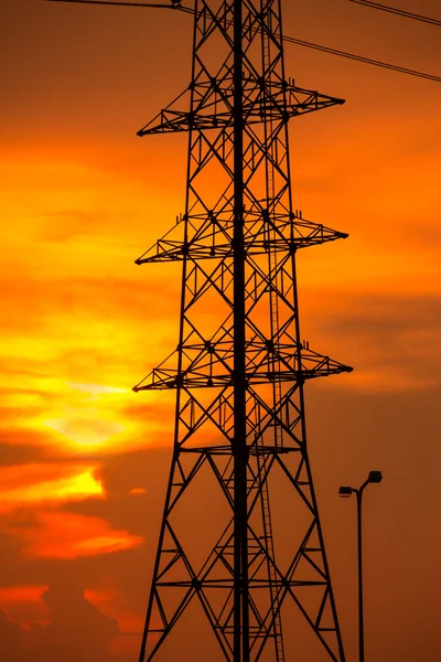 Wieże wysokiego napięcia na tle zachodu słońca. — Zdjęcie stockowe