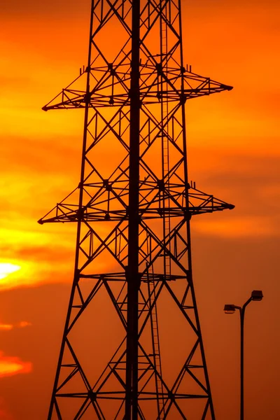 Nagyfeszültségű tornyok naplemente háttere. — Stock Fotó