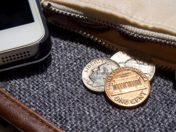 Oss dollar mynt placeras utanför plånboken med smartphone. — Stockfoto