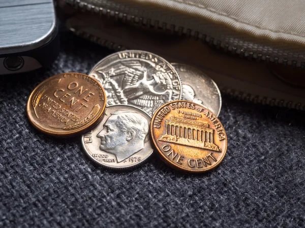 Nas dollar monety umieszczone na zewnątrz portfel z smartphone. — Zdjęcie stockowe