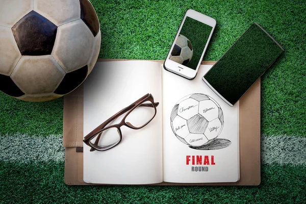 Soccer ball, sketch book, glasses, smartphone on green artificia — Stock fotografie