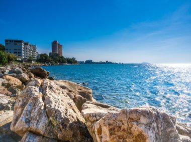 Güzel mavi gök, deniz ve Bang Saen Tayland taşlara.