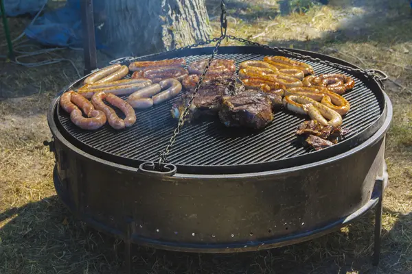 Duże kawałki pieczeni mięsnych i wędliniarskich na duży grill — Zdjęcie stockowe