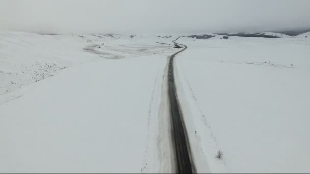 Автомобілі, що їдуть по зимовій дорозі . — стокове відео