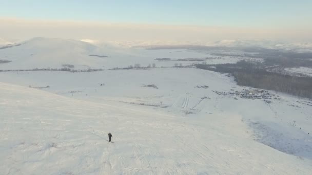 Narciarz narciarz zaczyna się zejście ze szczytu. — Wideo stockowe