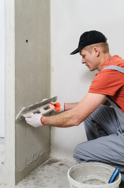 De werknemer legt het stucwerk op de muur — Stockfoto