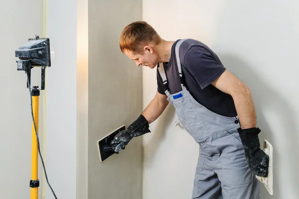 Werknemer maakt definitieve smoothing gips op de muur. — Stockfoto