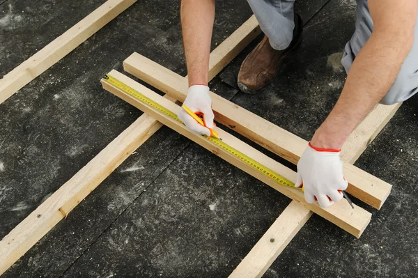 El trabajador mide una viga de madera . —  Fotos de Stock