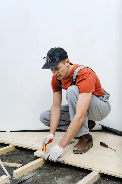 Työntekijä mittaa puulevy . — kuvapankkivalokuva