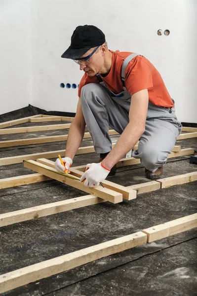 Worker measures off a wooden beam. — Stock Photo, Image