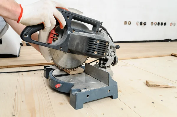 Worker cuts wooden floorboards. — Stock Photo, Image