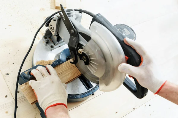 Worker cuts wooden floorboards. — Stock Photo, Image