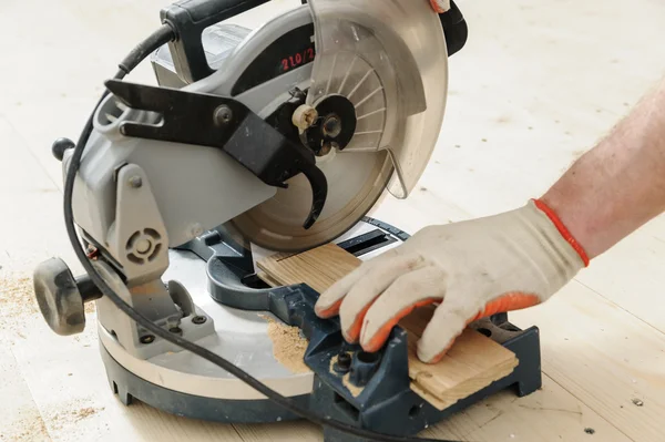 Worker cuts wooden floorboards. — Stock Photo, Image