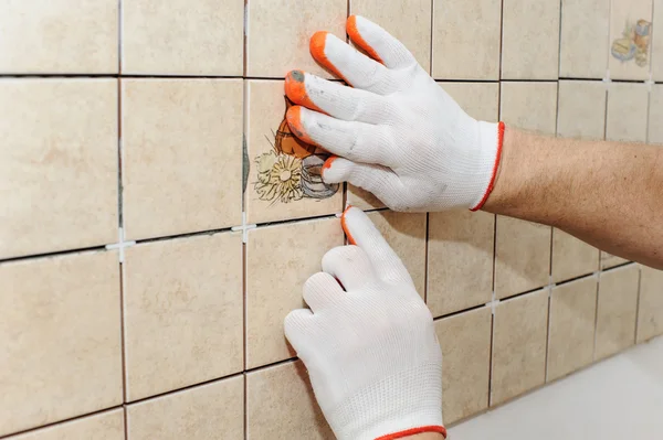 Trabajador poniendo azulejos en la pared en la cocina. — Foto de Stock