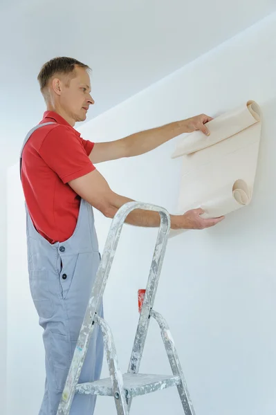 Trabajador pegando fondos de pantalla . — Foto de Stock