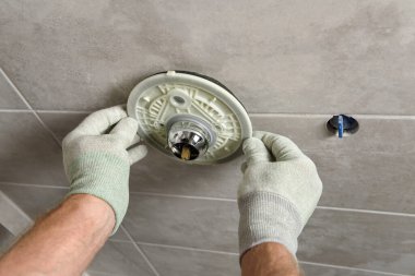 İşçinin elleri dahili bir musluk takıyor..