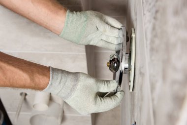 İşçinin elleri dahili bir musluk takıyor..