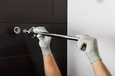 İşçi elleri, dahili duş musluğunun tüpünü yerleştirir..