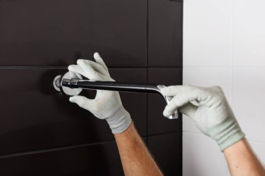 İşçi elleri, dahili duş musluğunun tüpünü yerleştirir..