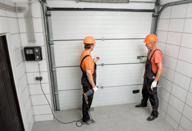 İşçiler garaja asansör kapıları kuruyor..