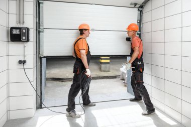 İşçiler garaja asansör kapıları kuruyor..
