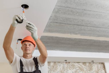 Elektrikçi tavana LED spot ışıkları kuruyor..