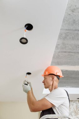 Elektrikçi tavana LED spot ışıkları kuruyor..