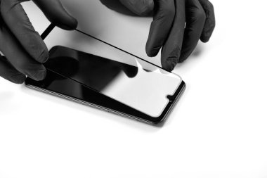 Bir adam akıllı telefonun ekranına koruyucu cam takıyor..