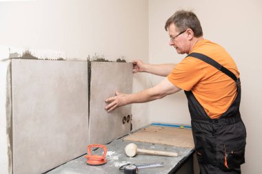 The tiler mutfak duvarına fayanslar yerleştiriyor..