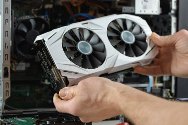 İnsan elleri bilgisayara bir video kartı yerleştiriyor..